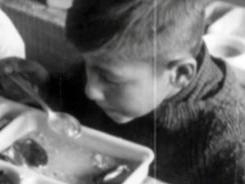 Imagen de un niño en blanco y negro comiendo