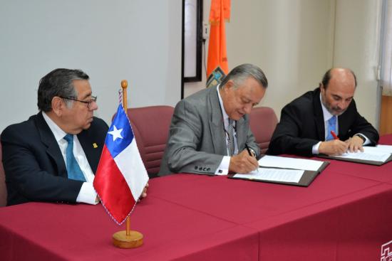 El director de la Dibam, Ángel Cabeza, firmando el convenio junto al rector de la UTA, Arturo Flores