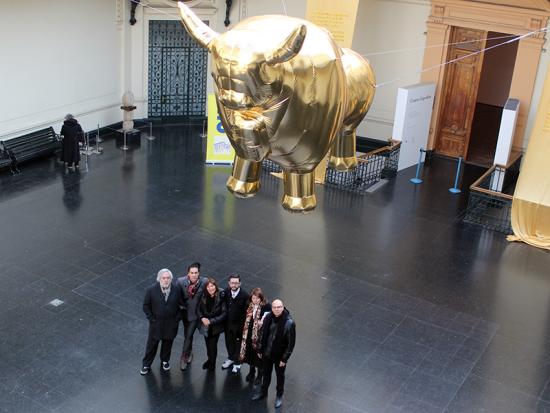 Los artistas bajo el toro dorado que flota en altura sobre el hall del Museo.