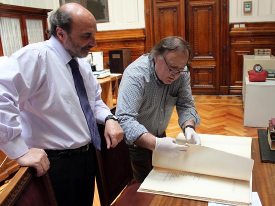 Director de la Dibam y Subdirector (s) de la Biblioteca Nacional revisan los documentos.